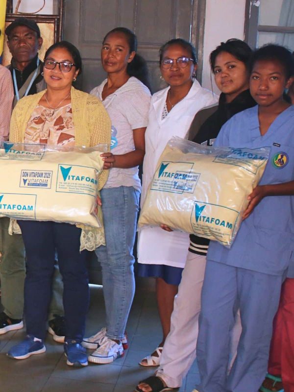 Équipe Vitafoam avec matelas emballés, partenaire literie hôtelière professionnelle Madagascar