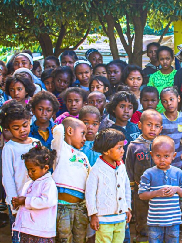 Groupe d'enfants uniforme scolaire avec personnel Vitafoam, événement communautaire matelas Madagascar